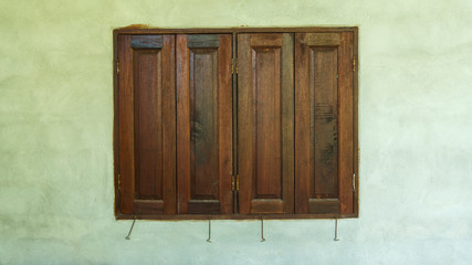 Old wooden windows frame on cement wall.