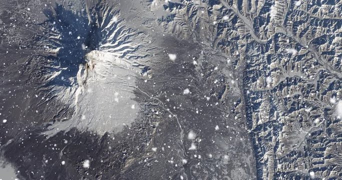 Vertical aerial ascent through heavy falling snow, over Kamchatka Peninsula, Russia. Elements of this image furnished by NASA. 
