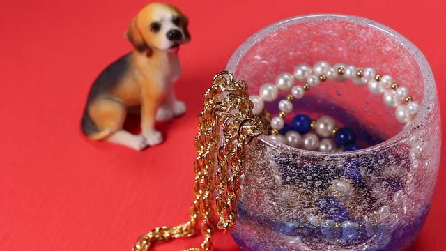 グラスに入った宝飾品と犬の置物