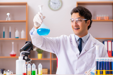 Young handsome biochemist working in the lab 