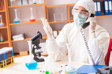 Young biochemist wearing protective suit working in the lab