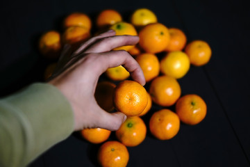 A human hand holding a clementine tangerine 