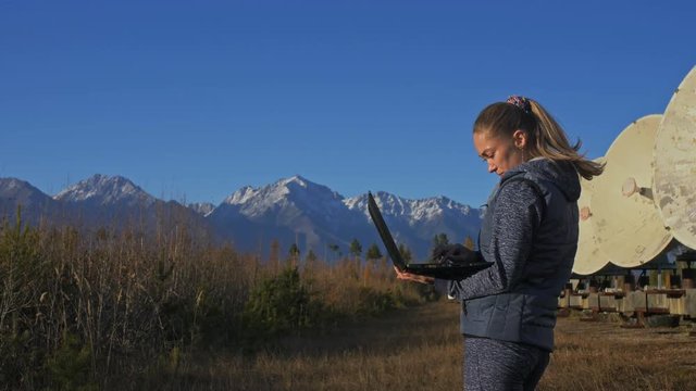 Woman student operator of institute of Solar Terrestrial Physics monitors communication equipment in notebook. Unique array solar radio telescope. Sun Solar Radio Telescope. The 'Quasar' observatory