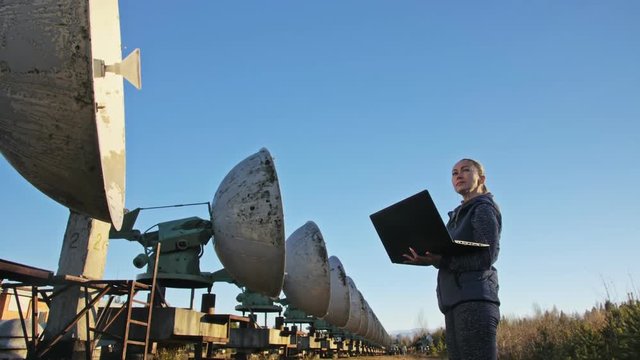 Woman student operator of institute of Solar Terrestrial Physics monitors communication equipment in notebook. Unique array solar radio telescope. Sun Solar Radio Telescope. The 'Quasar' observatory