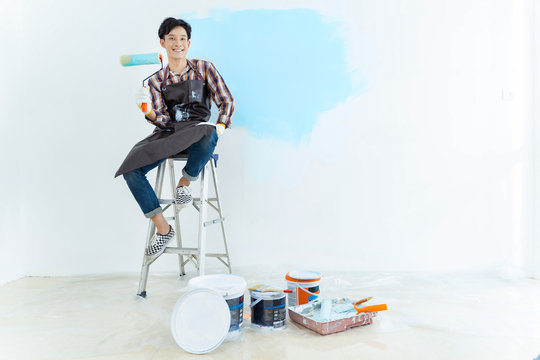 Asian Man Painting Wall At Home