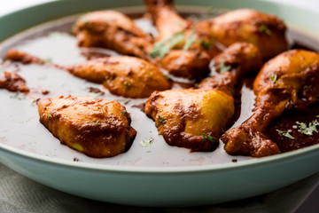 Chicken leg / drumstick curry or Murg Tangri/tangdi masala. Served in a bowl over moody background. Selective focus