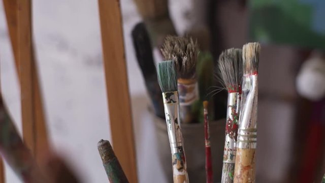 Close up water color paintbrush in artist studio slow motion