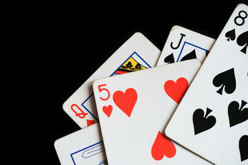 Several playing cards on a dark background close up