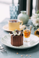 Crème brûlée with chocolate dessert with flowers. Foodstyling with tea on wooden background.