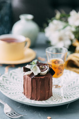 Crème brûlée with chocolate dessert with flowers. Foodstyling with tea on wooden background.