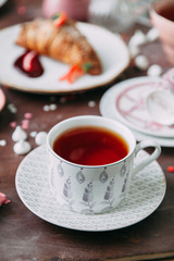 Croissants on a chic table with coffee and desserts. Food styling and layout with jam and berries.