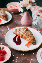 Croissants on a chic table with coffee and desserts. Food styling and layout with jam and berries.