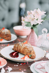 Croissants on a chic table with coffee and desserts. Food styling and layout with jam and berries.