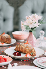 Croissants on a chic table with coffee and desserts. Food styling and layout with jam and berries.