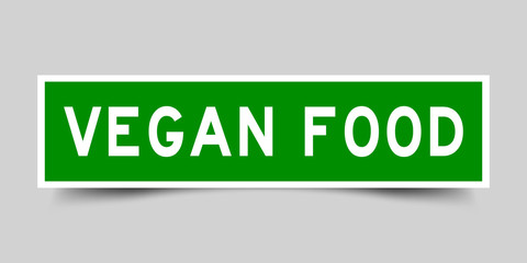 Square green sticker label in word vegan food on gray background