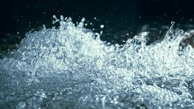 Slow motion of waves on dark water surface with play of flecks of bright light close up. Amazing dramatic natural background. Shooting with 180fps. Epic mystical and magic night view. Crystal clear