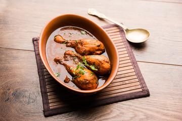 Chicken leg / drumstick curry or Murg Tangri/tangdi masala. Served in a bowl over moody background. Selective focus