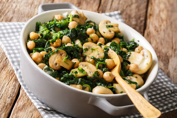 Delicious braised chickpeas with spinach and mushrooms closeup in a bowl. horizontal