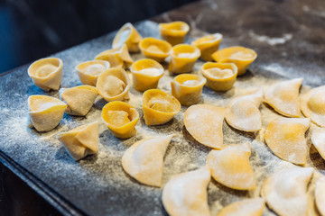 Chef making circle shape Ravioli by filling sage and butter on pasta dough.