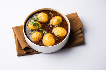 Fried egg curry or anda masala served in a bowl. selective focus