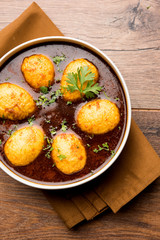 Fried egg curry or anda masala served in a bowl. selective focus