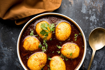 Fried egg curry or anda masala served in a bowl. selective focus