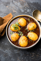 Fried egg curry or anda masala served in a bowl. selective focus