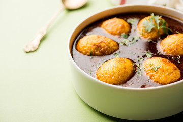 Fried egg curry or anda masala served in a bowl. selective focus