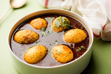 Fried egg curry or anda masala served in a bowl. selective focus