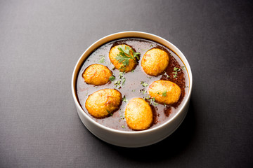 Fried egg curry or anda masala served in a bowl. selective focus