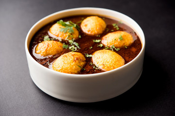 Fried egg curry or anda masala served in a bowl. selective focus