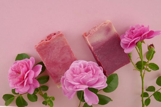 pink soap  with rose extract.soap and  pink rose flower close-up on a light pink background. Organic Cosmetic Spa Body Kit