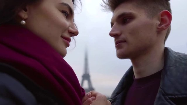 loving couple is embracing in Paris in autumn cloudy day, touching by faces, close-up view