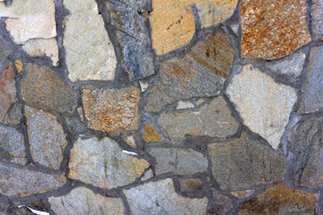 Neatly stacked rough cut stone wall seamless texture background.