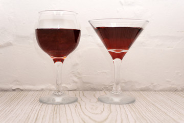 Glasses of red wine with food on table closeup .