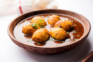 Fried egg curry or anda masala served in a bowl. selective focus