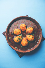 Fried egg curry or anda masala served in a bowl. selective focus