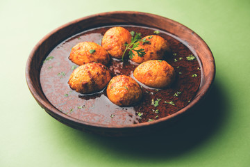 Fried egg curry or anda masala served in a bowl. selective focus