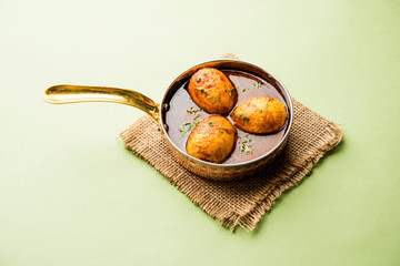 Fried egg curry or anda masala served in a bowl. selective focus