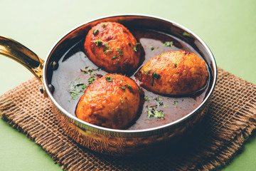 Fried egg curry or anda masala served in a bowl. selective focus