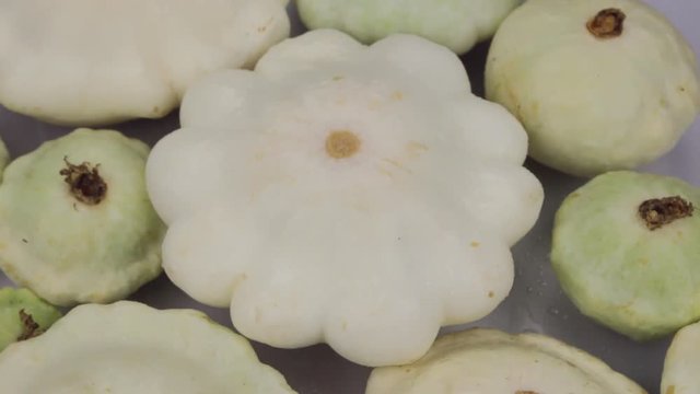Raindrops falling on rotating squashes. Close-up.
