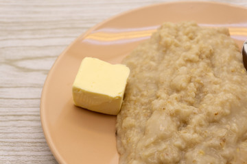 A bowl of white corn grits on a blue plaid placemat .
