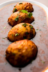 Fried egg curry or anda masala served in a bowl. selective focus