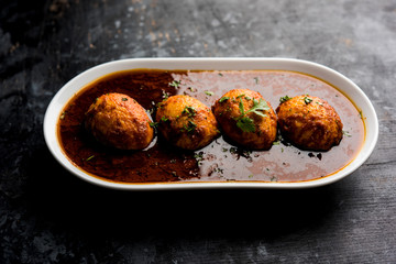 Fried egg curry or anda masala served in a bowl. selective focus
