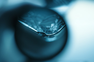 Blurred at high magnification background with broken glass and a damaged smartphone case in a repair shop. Blue toning