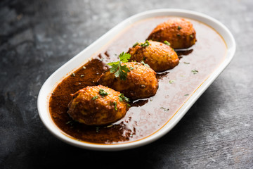 Fried egg curry or anda masala served in a bowl. selective focus