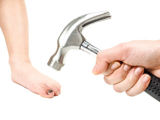 Male hand holding hammer over child's foot with blue big toe nail