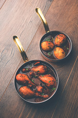 anda/egg curry with tangri/tangdi chicken masala. served in a serving pan. selective focus