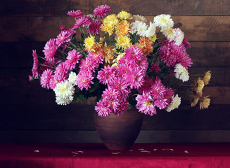 Chrysanthemums. Autumn bouquet in a clay jug.