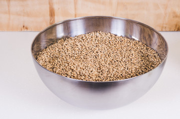 Caramel malt in stainless bowl. Craft beer brewing from grain barley pale malt in process. Ale or lager from pilsner malt